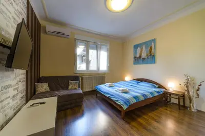 a bedroom with a bed and a couch at Parliament Apartment in Belgrade