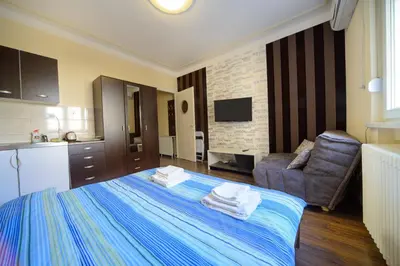 a hotel room with a bed and a couch at Parliament Apartment in Belgrade