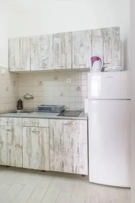 a kitchen with white cabinets and a white refrigerator at Apartment River Walk in Belgrade