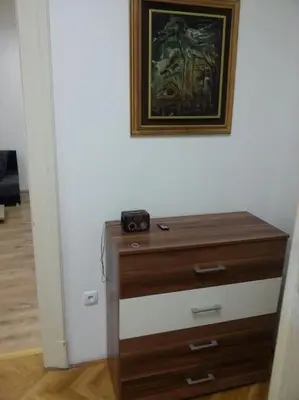a wooden dresser in a room with a picture on the wall at Apartment River Walk in Belgrade