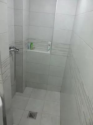 a white bathroom with a shower and a sink at Apartment River Walk in Belgrade