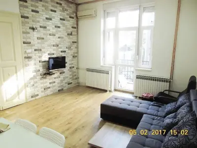 a living room with a couch and a brick wall at Apartment River Walk in Belgrade
