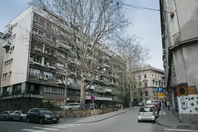a street with cars parked in front of a building at Central Belgrade Apartment 4 in Belgrade