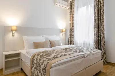 a white bedroom with a large bed and a window at Central Belgrade Apartment 4 in Belgrade