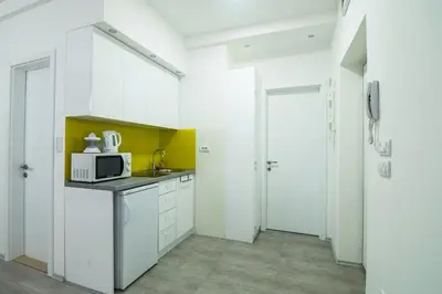 a kitchen with white cabinets and a microwave at Bohemian Quarter Apartment -1 Min to Skadarlija - Walk Everywhere in Belgrade
