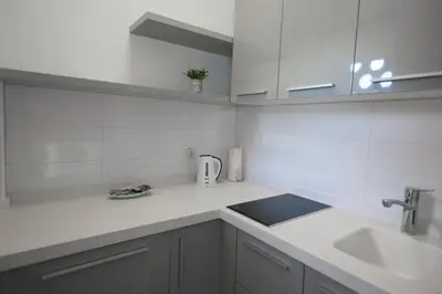 a white kitchen with a sink and a toaster at Aria Royal Nusic apartment in Belgrade