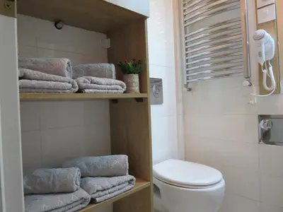 a bathroom with a toilet and a bunch of towels at Aria Royal Nusic apartment in Belgrade