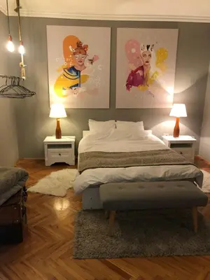 a bedroom with a bed with three pictures on the wall at Apartment Vivian in Belgrade