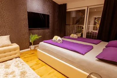 two beds in a room with purple pillows at #1 Lux Villa with Pool, Gameroom, Spa, Zen Yard #Free airport transport# in Belgrade