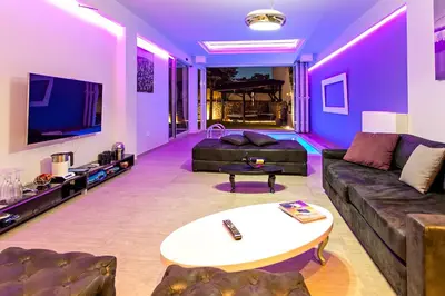 a living room with purple lighting and a couch at #1 Lux Villa with Pool, Gameroom, Spa, Zen Yard #Free airport transport# in Belgrade