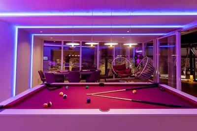 a pool table in a living room with a table and chairs at #1 Lux Villa with Pool, Gameroom, Spa, Zen Yard #Free airport transport# in Belgrade