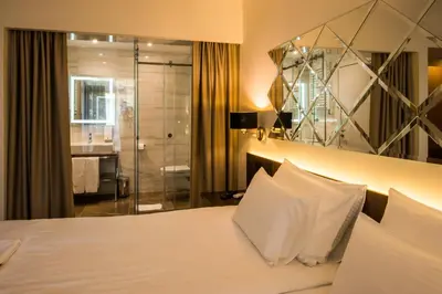 a hotel room with a bed and a shower at Hotel Spa Grad in Kovin