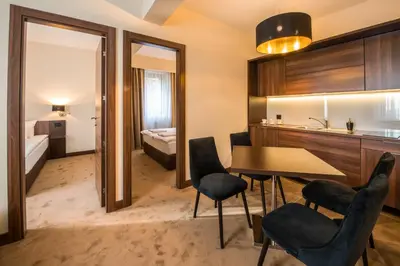 a room with a table and chairs and a bedroom at Hotel Spa Grad in Kovin