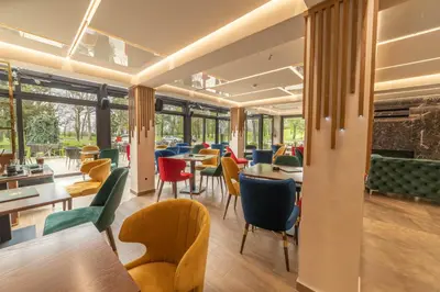 a restaurant with colorful chairs and tables and windows at Hotel Spa Grad in Kovin