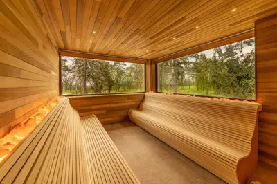a sauna with two benches and a large window at Hotel Spa Grad in Kovin