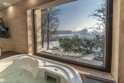 a bath tub in a bathroom with a large window at Hotel Spa Grad in Kovin