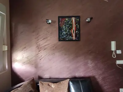 a wall with a painting on it with a couch at Apartment StefanA in Belgrade