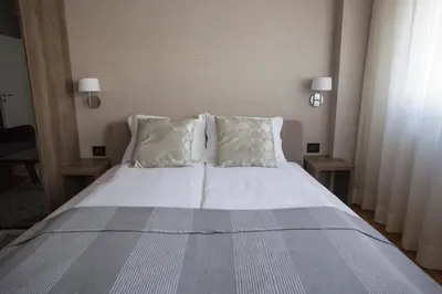 a bed with white sheets and pillows in a room at Dia Belgrade Arena Apartment in Belgrade