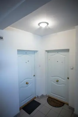 two white doors in a room with white walls at Dia Belgrade Arena Apartment in Belgrade