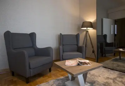 a living room with two chairs and a coffee table at Dia Belgrade Arena Apartment in Belgrade