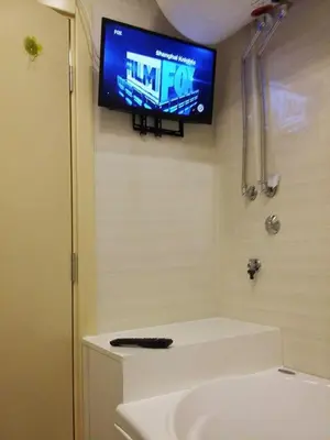 a tv on the wall of a bathroom with a sink at Lux Life Apartment in Belgrade