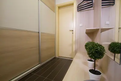 a hallway with two potted plants and a door at Lux Life Apartment in Belgrade