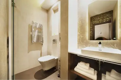 a bathroom with a toilet and a sink and a mirror at NV Luxury Suites & Spa in Belgrade