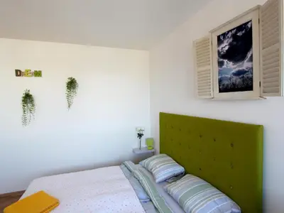 a bed with a green headboard in a bedroom at Dream Apt with parking in Belgrade
