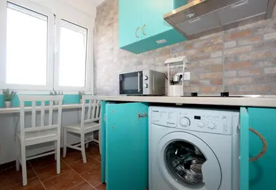 a kitchen with a washing machine under a counter at Dream Apt with parking in Belgrade