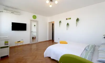 a white bedroom with a bed and a tv at Dream Apt with parking in Belgrade
