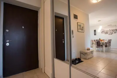 a hallway with a black door and a dining room at Central City Apartments in Belgrade