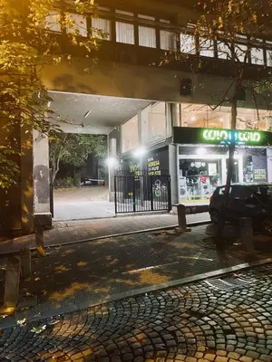 an empty street at night with a car dealership at Central City Apartments in Belgrade