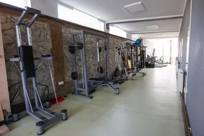 a gym with rows of exercise equipment on the wall at Marex Centar in Jabuka