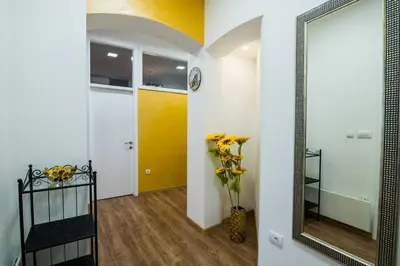 a hallway with a mirror and a vase of flowers at Bright City Center Apartment with Balcony in Belgrade