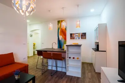 a kitchen and living room with a counter and a table at Bright City Center Apartment with Balcony in Belgrade