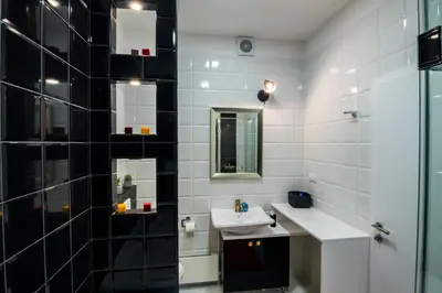 a white bathroom with a sink and a mirror at Bright City Center Apartment with Balcony in Belgrade
