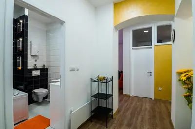 a bathroom with a sink and a toilet and a door at Bright City Center Apartment with Balcony in Belgrade