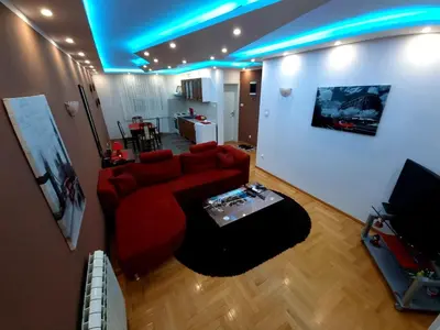 a living room with a red couch and a table at Luxury Apartments Belgrade in Belgrade