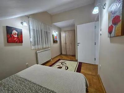a small bedroom with a bed and a door at Luxury Apartments Belgrade in Belgrade