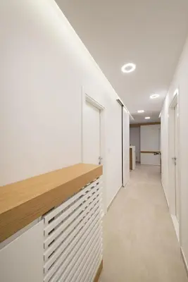 a hallway of an office building with white walls and a wooden counter at Vivio Luxury Apartment in Belgrade