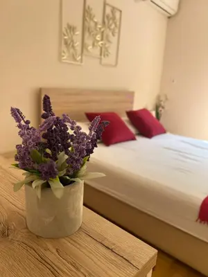 a bedroom with a bed and a vase of flowers on a table at Orchid House in Belgrade