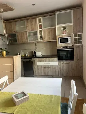 a kitchen with wooden cabinets and a table with a table sidx sidx at Orchid House in Belgrade