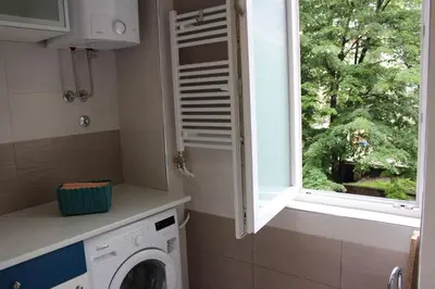 a laundry room with a washing machine and a window at Orchid House in Belgrade