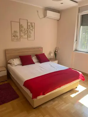 a bedroom with a large bed with red pillows at Orchid House in Belgrade