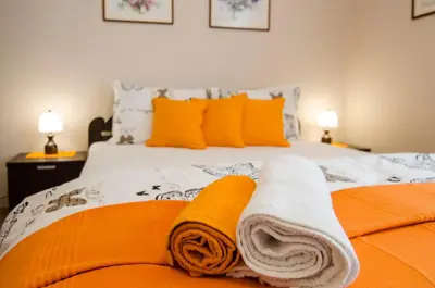 a bed with orange and white towels on it at Villa Rose in Belgrade