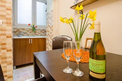 a bottle of wine and two glasses on a table at Villa Rose in Belgrade