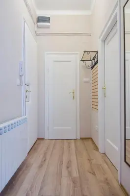an empty hallway with a white door and wooden floors at Villa Rose in Belgrade