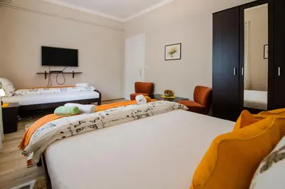 a hotel room with two beds and a tv at Villa Rose in Belgrade