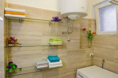 a bathroom with a toilet and towels on a wall at Villa Rose in Belgrade