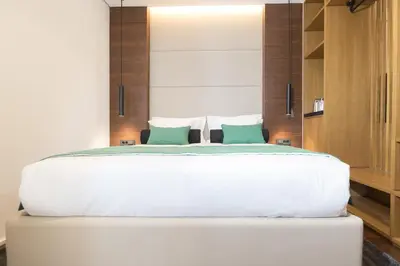 a bedroom with a large white bed with green pillows at Dominic Smart & Luxury Suites - Parliament in Belgrade